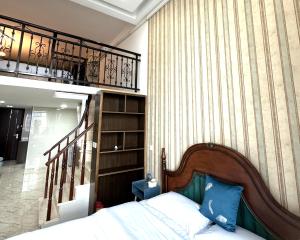 a bedroom with a bed and a book shelf at April Fair Duplex Apartment Guagnzhou South Railway Station Min Jie Branch in Guangzhou