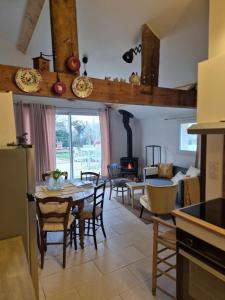 a kitchen and living room with a table and chairs at A La Maison in Les Repôts