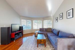 un soggiorno con un divano blu e una TV di Green Cottage a McMinnville