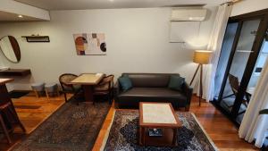 a living room with a couch and a table at Lorena Residence - Cozy Flat with Balcony in São Paulo