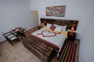 a bedroom with a bed with a heart drawn on it at RUSTICA HOTELES CUSCO Urubamba in Urubamba +30 photos