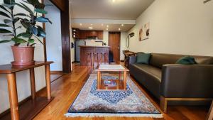 a living room with a couch and a table at Lorena Residence - Cozy Flat with Balcony in São Paulo