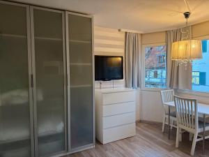 a living room with a dining table and a television at Historisches Fischerviertel in Ulm