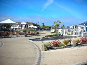a parking lot with tables and chairs and a restaurant at Chalet 151, Perran Sands in Perranporth