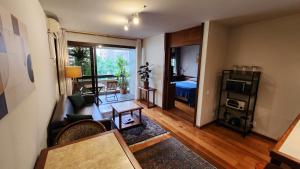 a living room with a room with a bed and a couch at Lorena Residence - Cozy Flat with Balcony in São Paulo