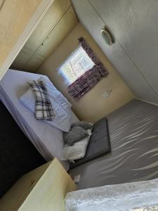 a small room with a bed and a window at The Hive on The Chase Ingoldmells in Skegness