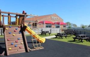 a playground with a slide in front of a building at The Hive on The Chase Ingoldmells in Skegness