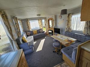 a living room with a couch and a table in a caravan at The Hive on The Chase Ingoldmells in Skegness