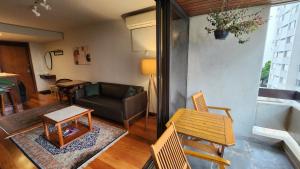 a living room with a couch and a table at Lorena Residence - Cozy Flat with Balcony in São Paulo