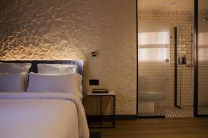 a bedroom with a white bed and a shower at Letoh Letoh Bilbao in Bilbao