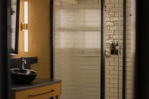 a bathroom with a glass shower with a sink at Letoh Letoh Bilbao in Bilbao