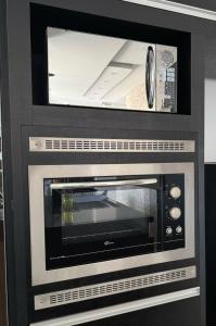 a microwave oven sitting inside of a kitchen at Refúgio na Praia Casa Confortável e Acolhedora in São Francisco do Sul
