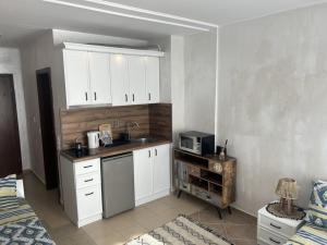 ソゾポルにあるNiya Apartments Kavaci Sozopolの白いキャビネットとシンクのあるキッチン
