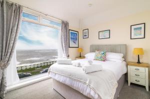 a bedroom with a large window with a view of the ocean at The Wheeldale in Whitby