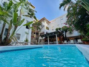 a swimming pool in front of a building at Hotel San Marco  in Santo Domingo