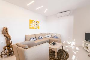a living room with a couch and a table at Villa Infinium TWO, Sunset views 10' from Mykonos town! in Agios Stefanos