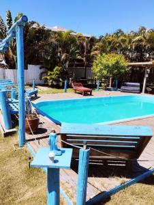 a swimming pool in a yard with a blue pool at Pousada Horizontes do Rosa in Praia do Rosa