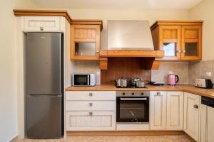 a kitchen with wooden cabinets and a stainless steel refrigerator at Villa Ourania near Myrtos in Divarata +38 photos
