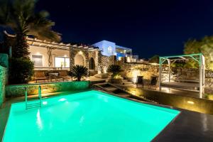 a swimming pool in front of a house at night at Villa Infinium TWO, Sunset views 10' from Mykonos town! in Agios Stefanos