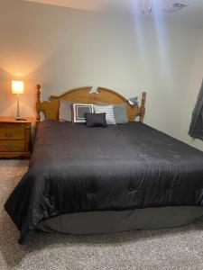 ein Schlafzimmer mit einem großen Bett mit einer schwarzen Bettdecke in der Unterkunft Cozy 3 Bedroom Home in Quiet Neighborhood in Amarillo