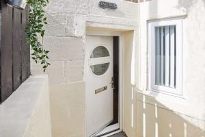 a white door on the side of a building at The Hamlet - North East Escapes in Tynemouth