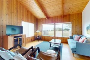 a living room with a couch and a tv at Whispering Wave in Gualala