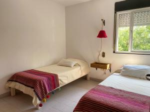 a bedroom with two beds and a window at Ideal para compartir en familia o con amigos in San Salvador de Jujuy