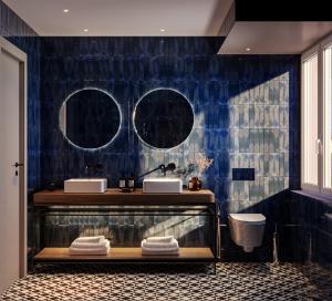 baño con 2 lavabos y una pared de azulejos azules en The Lince Braga, en Braga