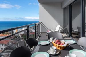 a balcony with a table with a basket of fruit at Amparo II by An Island Apart in Funchal