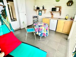 cocina con mesa, mesa y sillas en Appartement Tillet. O Coeur de Deshaies., en Deshaies