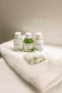 three bottles of medicine sitting on a white towel at Kosa Śpiew Joga i Spa in Kosewo
