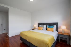 a bedroom with a large bed with yellow sheets at Amparo II by An Island Apart in Funchal