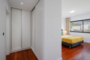 a bedroom with a bed and a large window at Amparo II by An Island Apart in Funchal