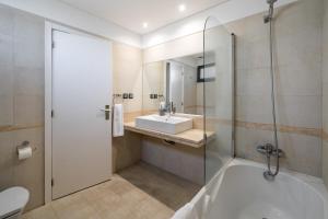 a bathroom with a bath tub and a sink at Amparo II by An Island Apart in Funchal