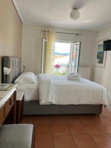 a bedroom with a large bed and a window at Mira Mare Hotel, Galaxidi in Galaxidhion
