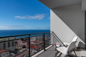 a balcony with two chairs and a view of the ocean at Amparo II by An Island Apart in Funchal