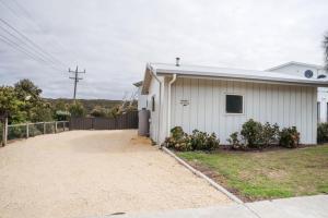 a white house with a driveway in front of it at Port Campbell Coastal Studio in Port Campbell