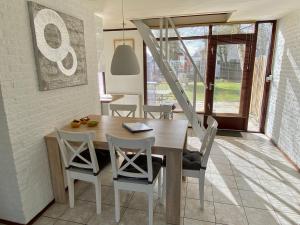 a dining room with a wooden table and chairs at Noordzeehuisje in Sint Maartensvlotbrug