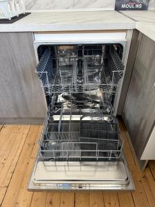 an open dishwasher with dishes inside of it at F2 vu sur l Allier pour 6 pers in Moulins