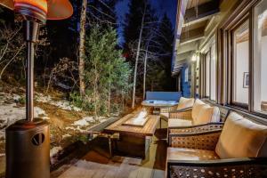 a screened porch with a table and chairs and a fireplace at Mountain Mansion With A Hot Tub And A Sauna in Morrison