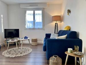a living room with a blue couch and a tv at 1001 - Appartement T3 au cœur de Pléneuf-Val-André in Pléneuf-Val-André