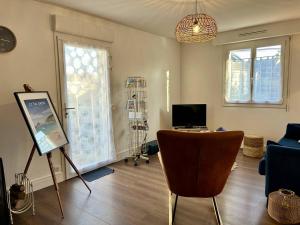 a living room with a table and a chair at 1001 - Appartement T3 au cœur de Pléneuf-Val-André in Pléneuf-Val-André