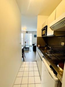 una cocina con fregadero y estufa en L'Ouvrage - Grand Studio - La Rochelle, en La Rochelle 6 fotos más