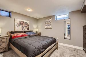 a bedroom with a bed and a painting of an elephant at Basement Guest Suite With A Pool Table A Hot Tub And A TV in Denver