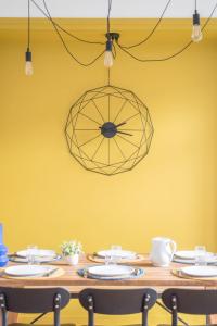 a dining room table with a yellow wall and a chandelier at BLEU TOUCAN - 700m plage - Parking in Saint-Nazaire
