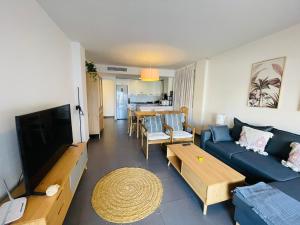 a living room with a blue couch and a tv at La Manga Beach Club Lateral by Alina365 in La Manga del Mar Menor