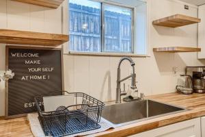 a kitchen sink with a dish rack on the counter at Guest Suite In West Denver With A Full KItchen in Wheat Ridge