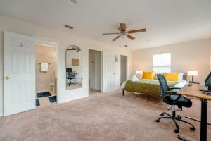 a bedroom with a bed and a desk with a chair at Full House HotTub Mins to UCF in Bithlo