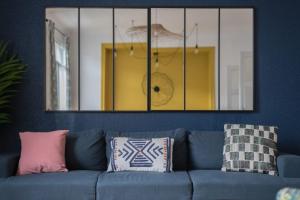a mirror above a blue couch in a living room at BLEU TOUCAN - 700m plage - Parking in Saint-Nazaire