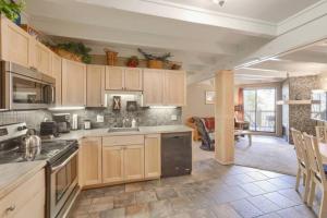a kitchen with wooden cabinets and a dining room at Pet Friendly With A Fireplace A Pool Near Mountain Biking And Skiing in Silverthorne